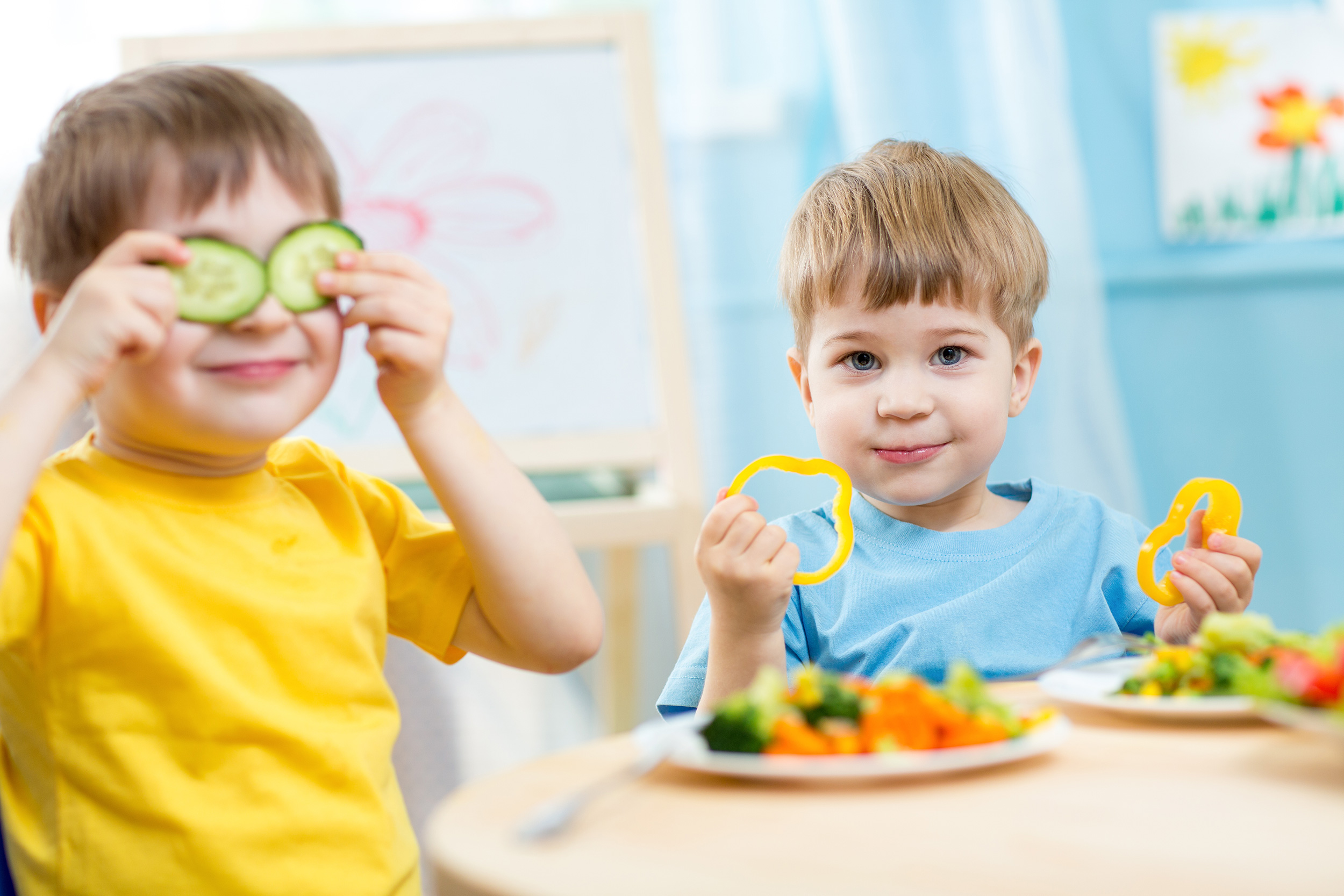 © Shutterstock Zwei Kinder spielen mit Gurken und Paprika