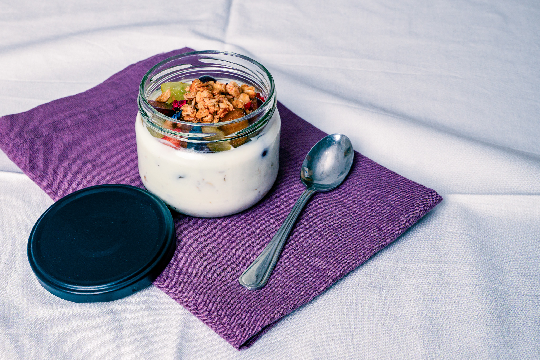 Abbildung von Frucht-Knusper-Müsli im Glas mit Löffel