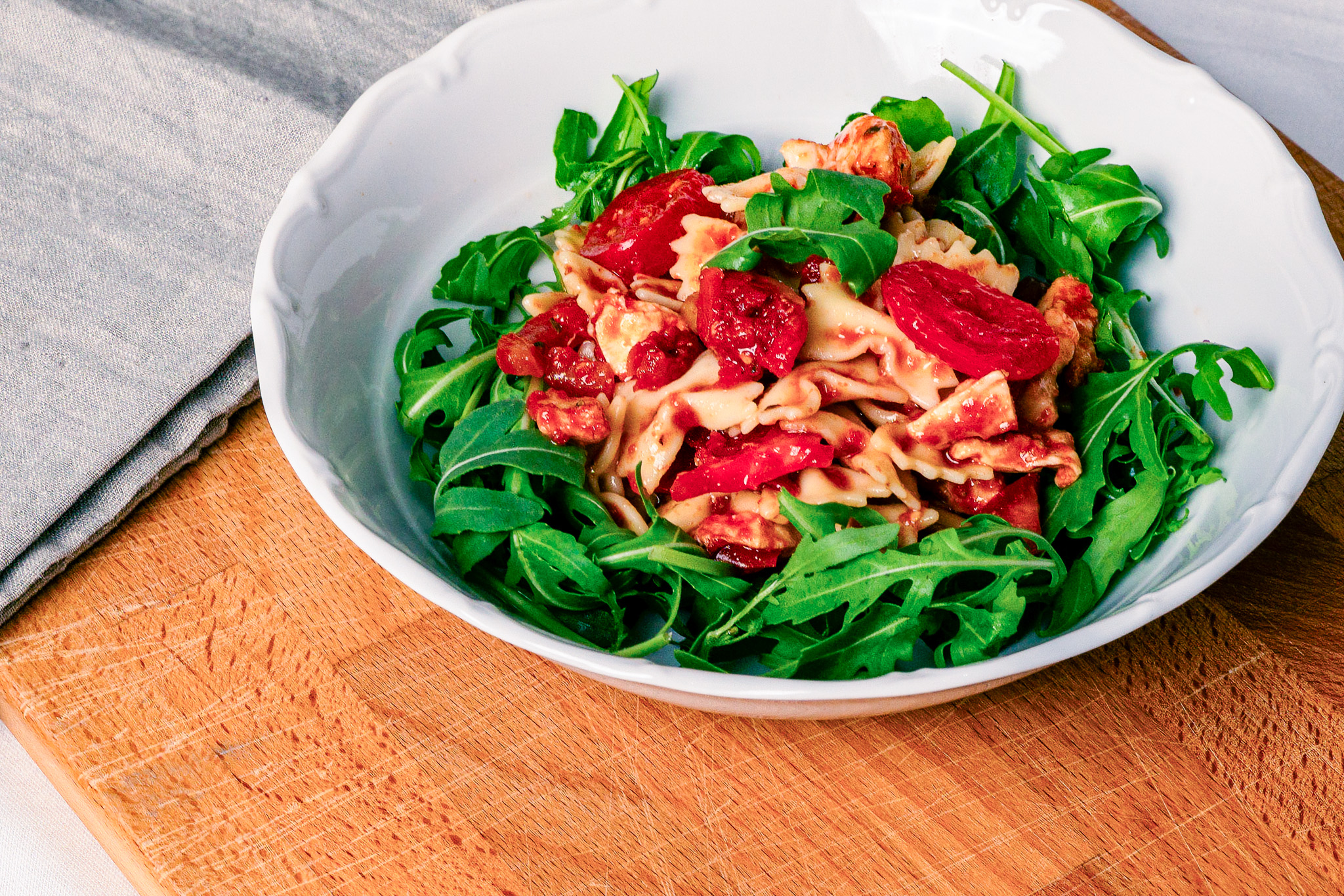 Abbildung von Mediterraner Nudelsalat im Teller auf Schneidbrett