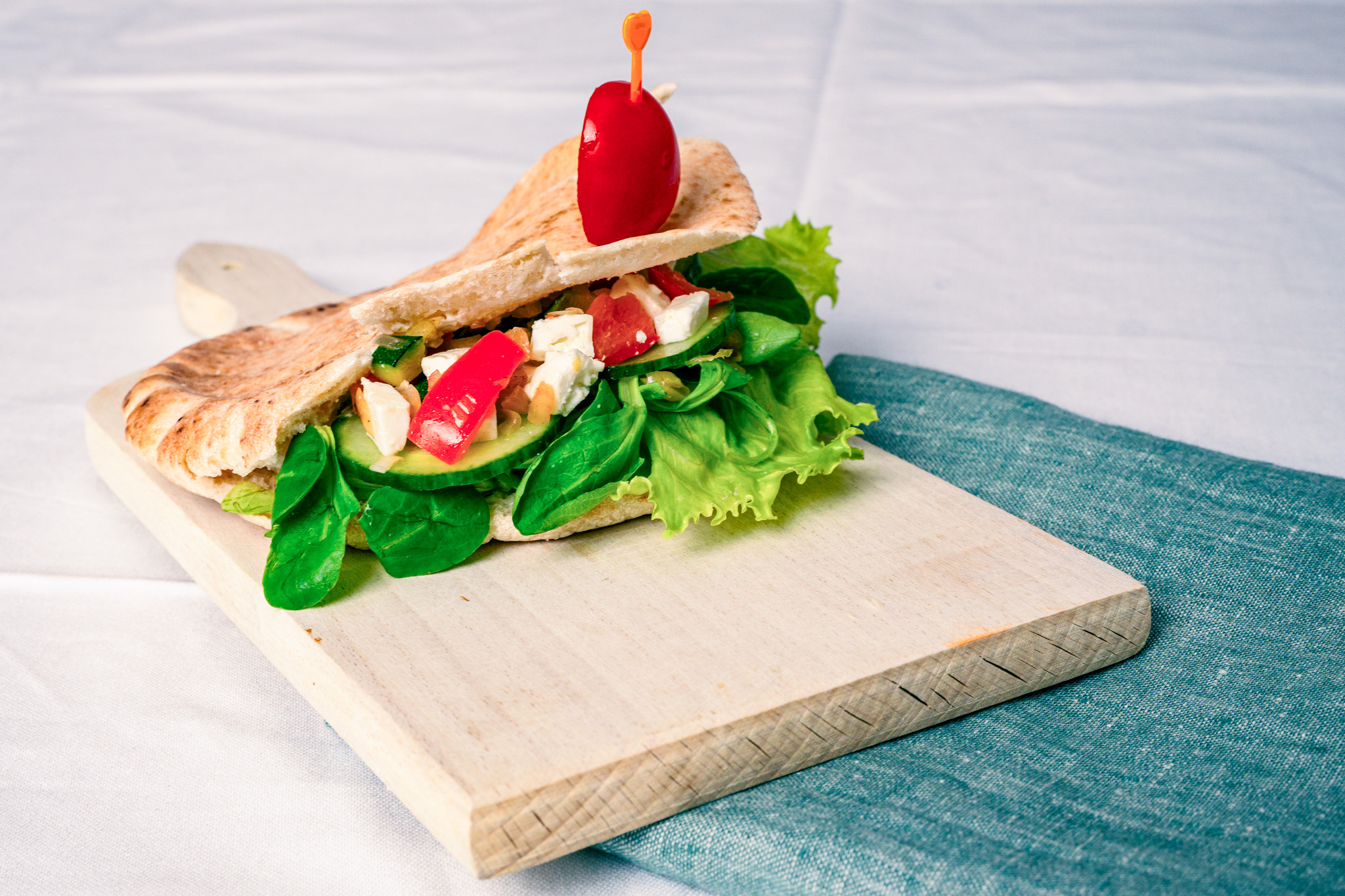 Abbildung von Gefülltes Pitabrot mit Gemüse/Vegetarischer Döner auf Schneidbrett