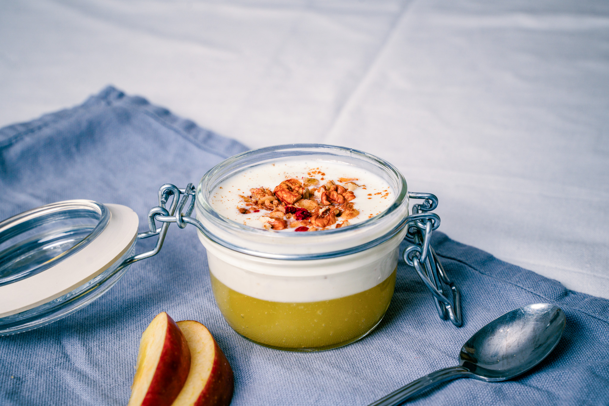 Abbildung von Apfel-Schicht-Joghurt im Glas mit Löffel